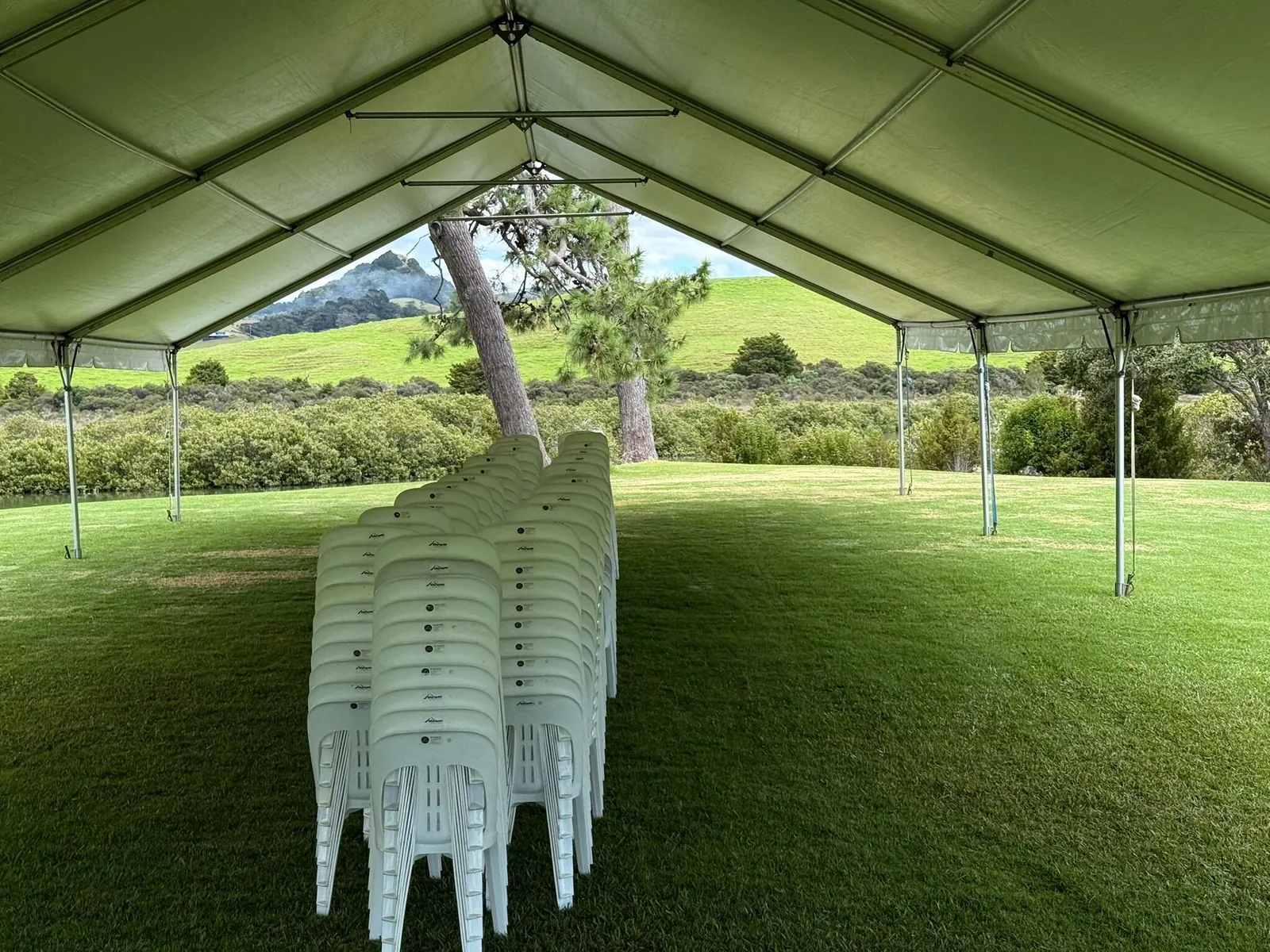 Chairs stacked under a freshly built marquee frame, ready for the event crew